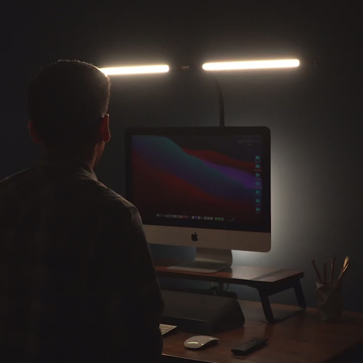 Man adjusting the angle of black desk light